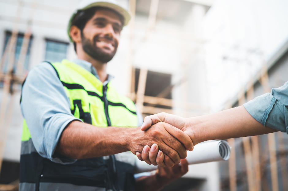 A picture of a construction worker shaking hands in agreement.